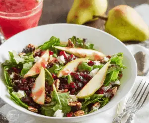 Fresh fall salad with mixed greens, sliced pears, cranberries, walnuts, and cranberry vinaigrette dressing.