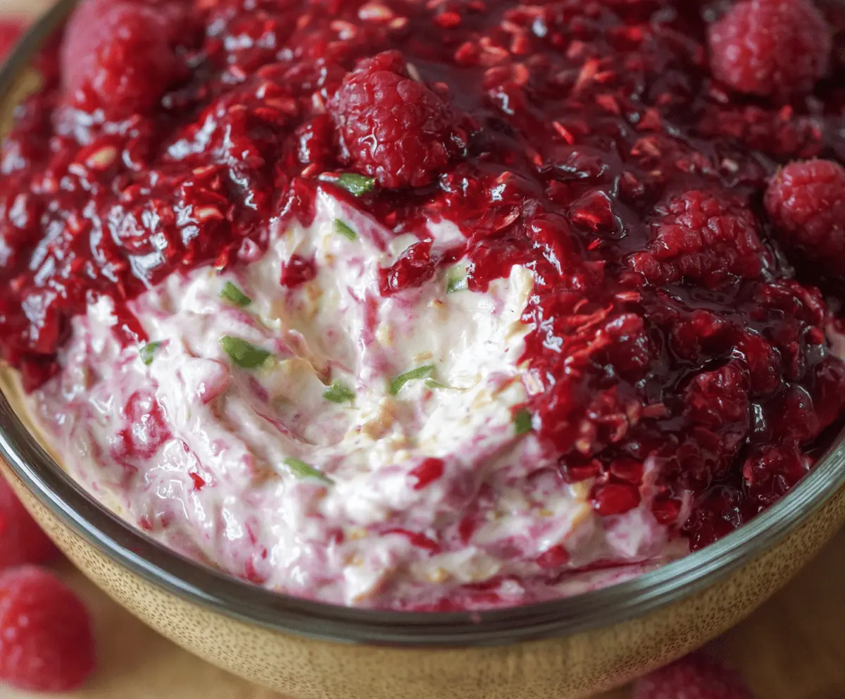 Creamy raspberry dip served with fresh raspberries on a white plate, perfect for dipping and snacking.