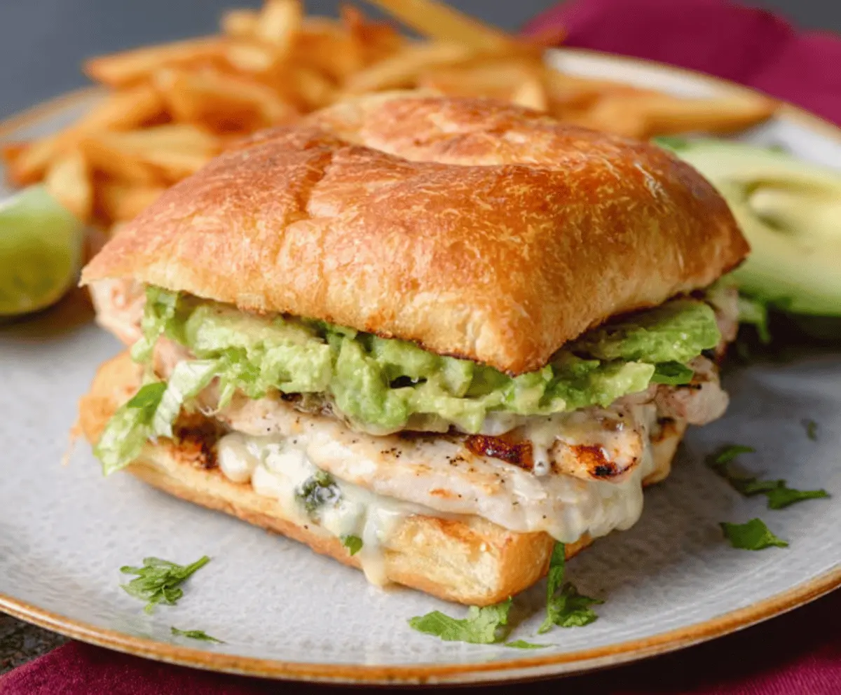 Delicious Chicken Avocado Melt Sandwich with melted cheese and fresh avocado on toasted bread.