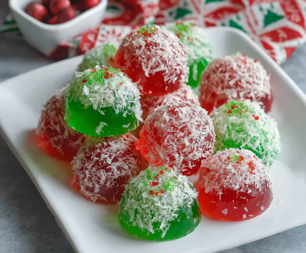Vibrant Christmas Jello Balls on a festive plate with holiday decorations in the background