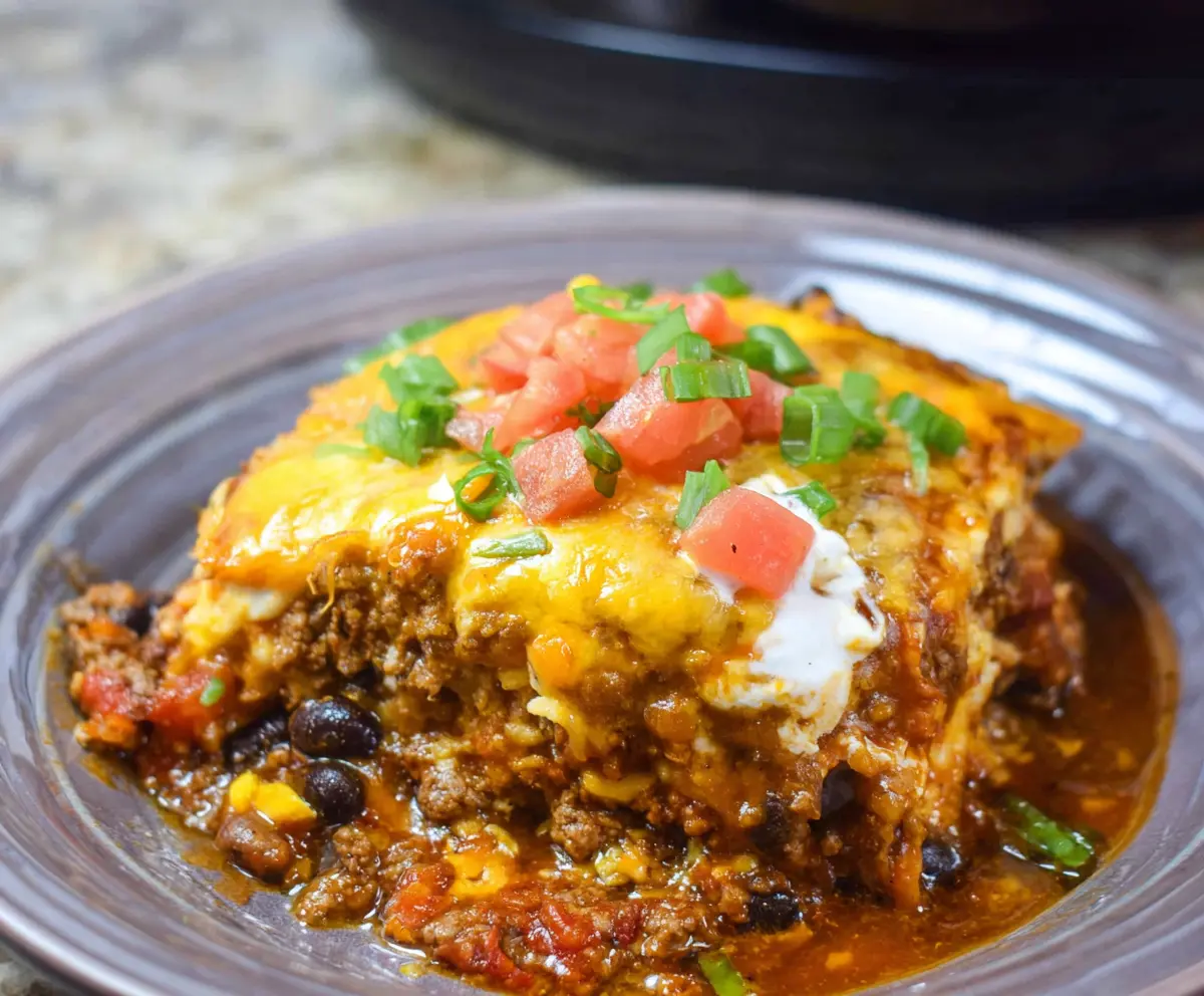 Delicious Crockpot Beef Enchilada Casserole topped with melted cheese and fresh cilantro.