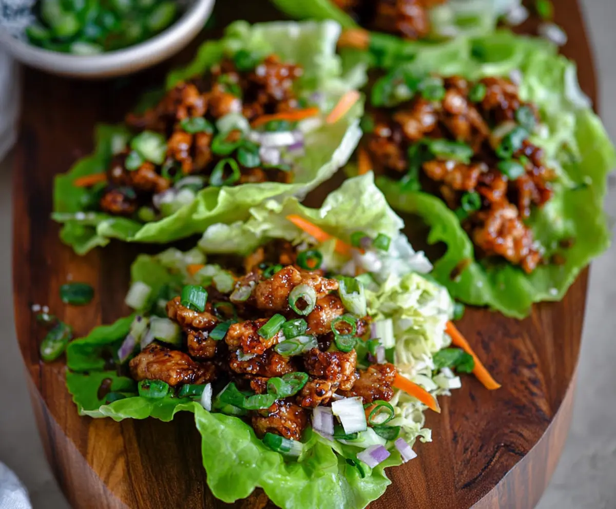 Delicious Hot Honey Chicken Lettuce Wraps topped with spicy honey glaze, served fresh on a plate.