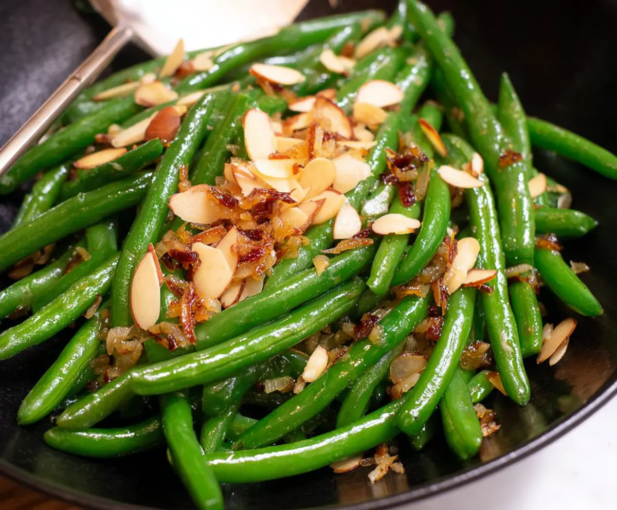 Delicious Green Bean Almondine with toasted almonds and fresh green beans on a white plate.